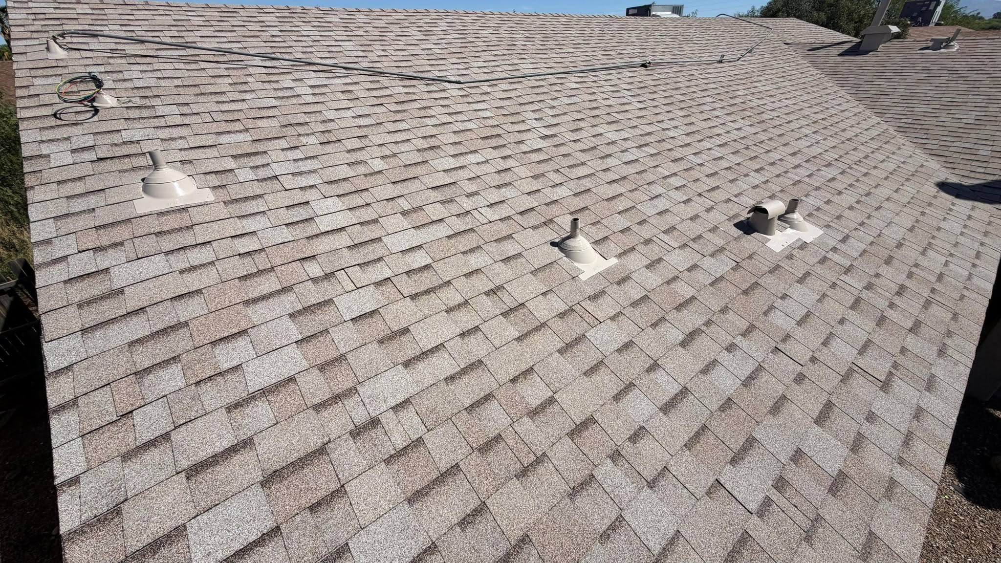 Completed gray asphalt shingle roof with roof vents.