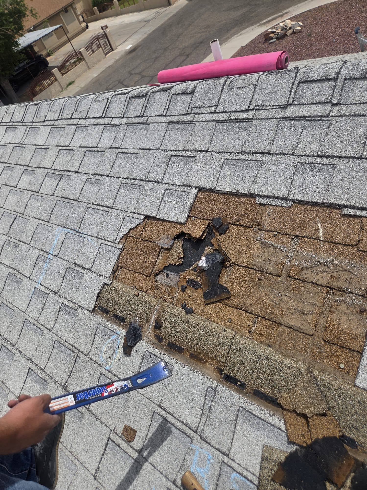 Close view of missing shingles and exposed roof decking.
