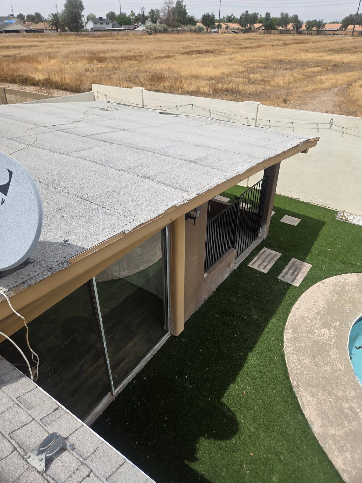 Low-slope roof inspection above a residential patio.